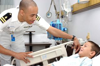 800px-US_Navy_040915-N-0000W-121_Lt._Charles_Dickerson_checks_on_a_young_patient_in_Ward_5B_of_the_U.S._Naval_Hospital,_Yokosuka